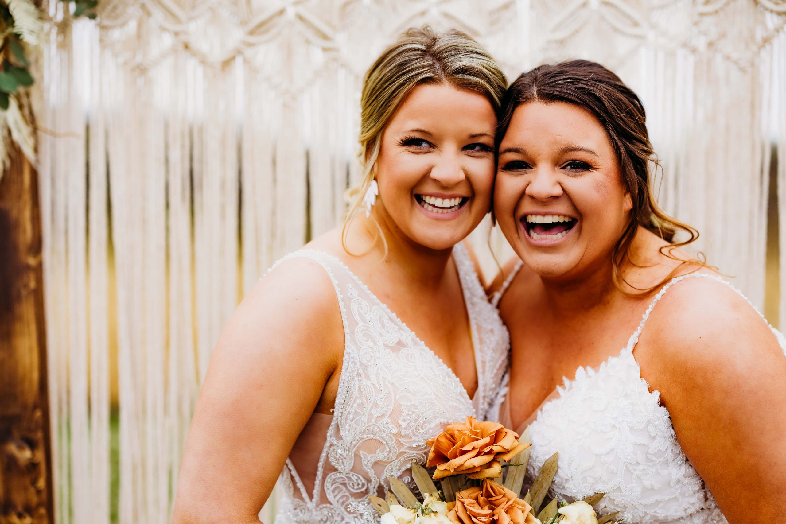 Brides stand cheek to cheek and laugh together, showing us how to look better in photos