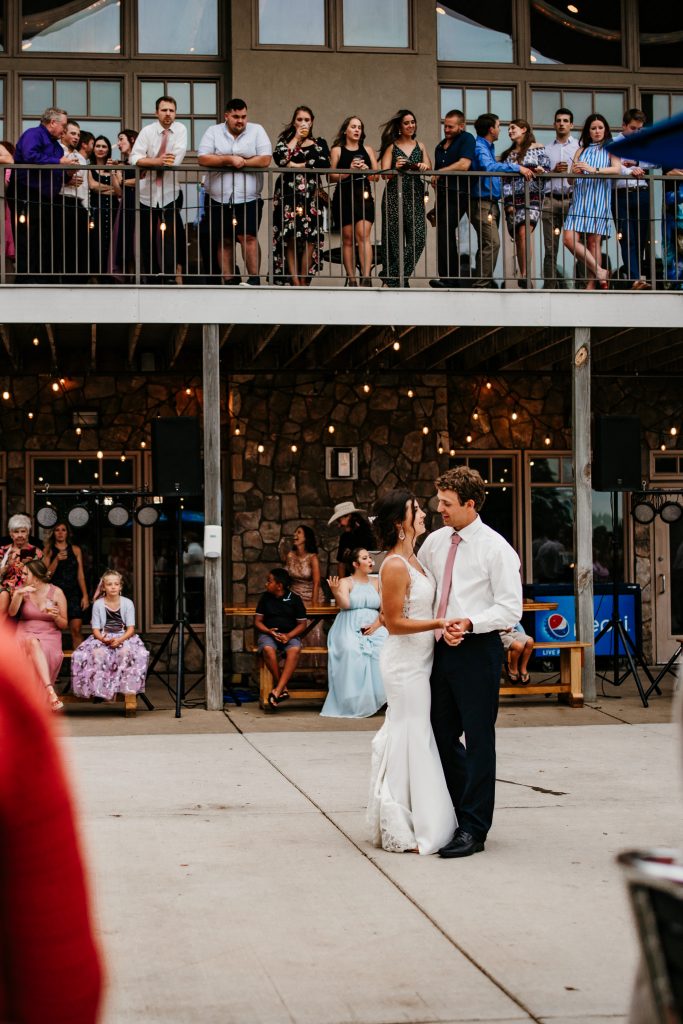 A couple dances together during their first dance outdoors