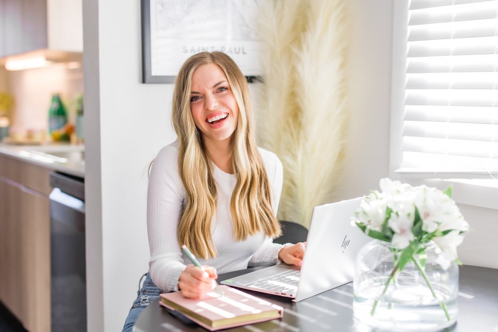 Women smiles over her laptop during her minnesota brand photography session