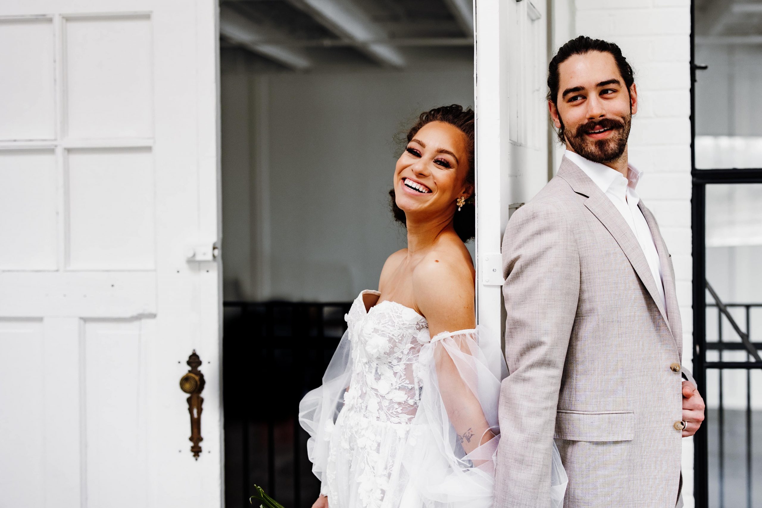 bride and groom smile in cover photo for a guide on choosing your wedding photographer