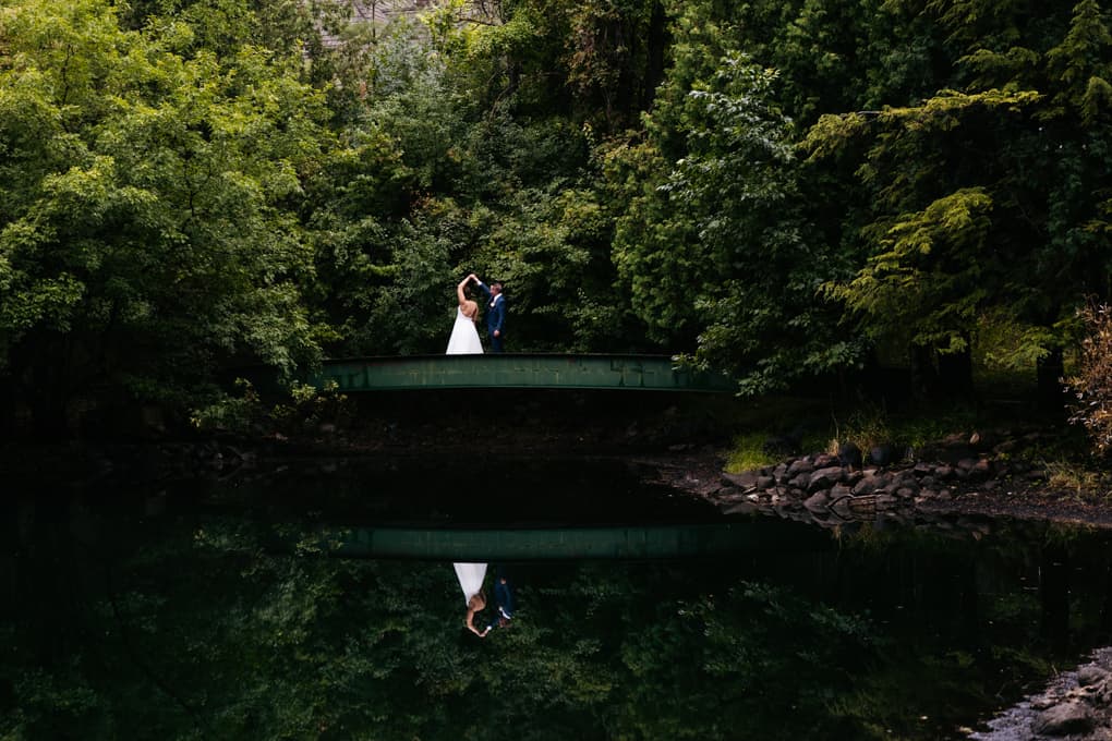 Minnesota wedding photographer images by nic captures couple dancing on a bridge at The Woods Chapel wedding vene