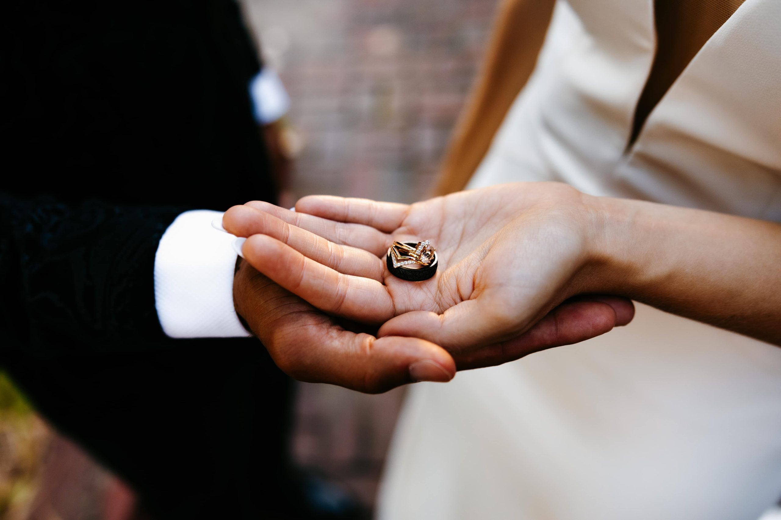 Bride and groom hold their wedding rings