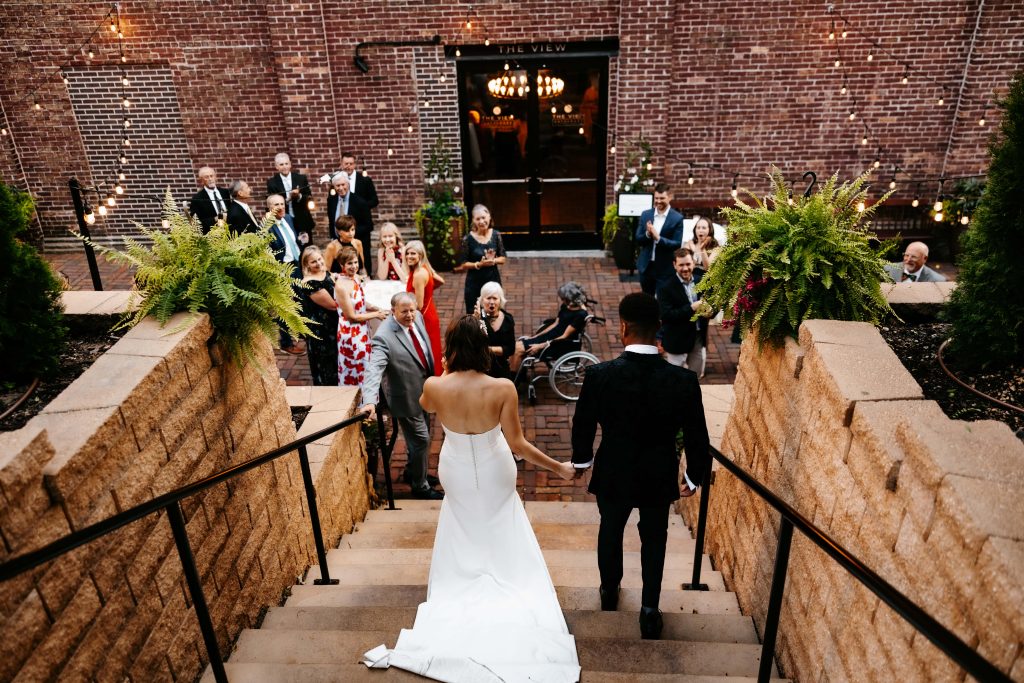 A couple walks into their reception after using wedding timeline planning to create space for portraits