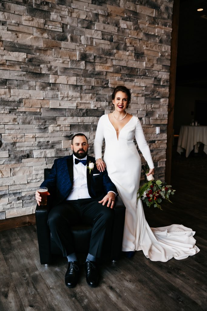 Bride leans on a chair and rests on the shoulder of her husband at her Tattersall Event Center wedding