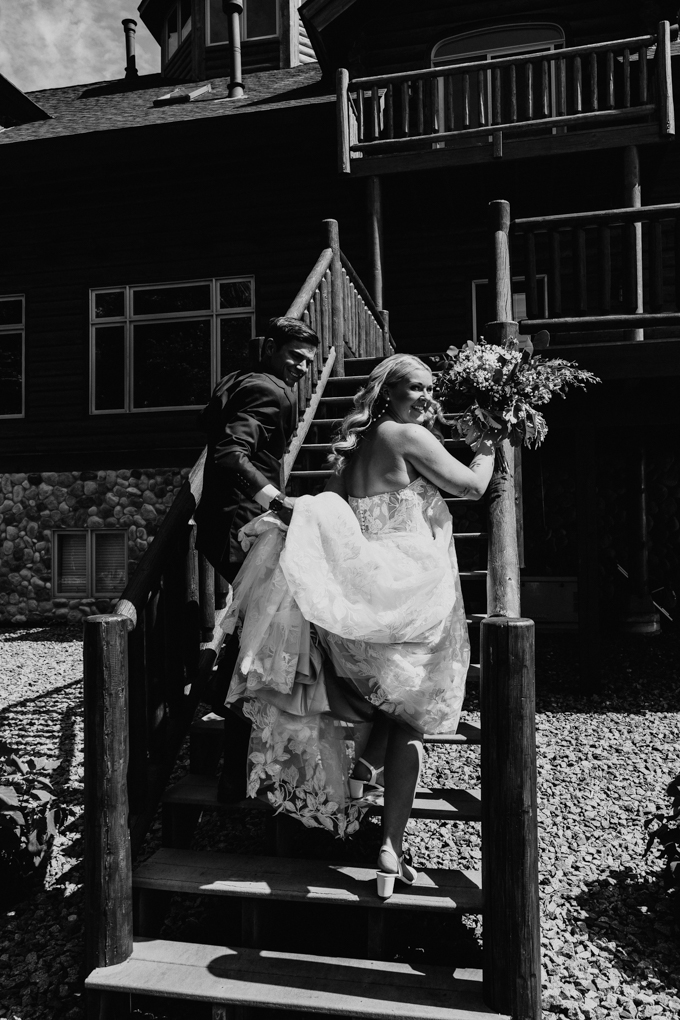 Couple walks up the log cabin stairs after their wedding ceremony at their 