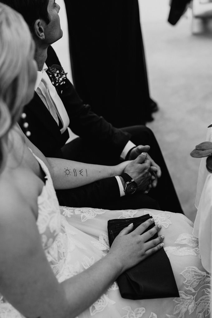 Bride and groom hold hands at the table during speeches at their Northern Oaks Events Wedding