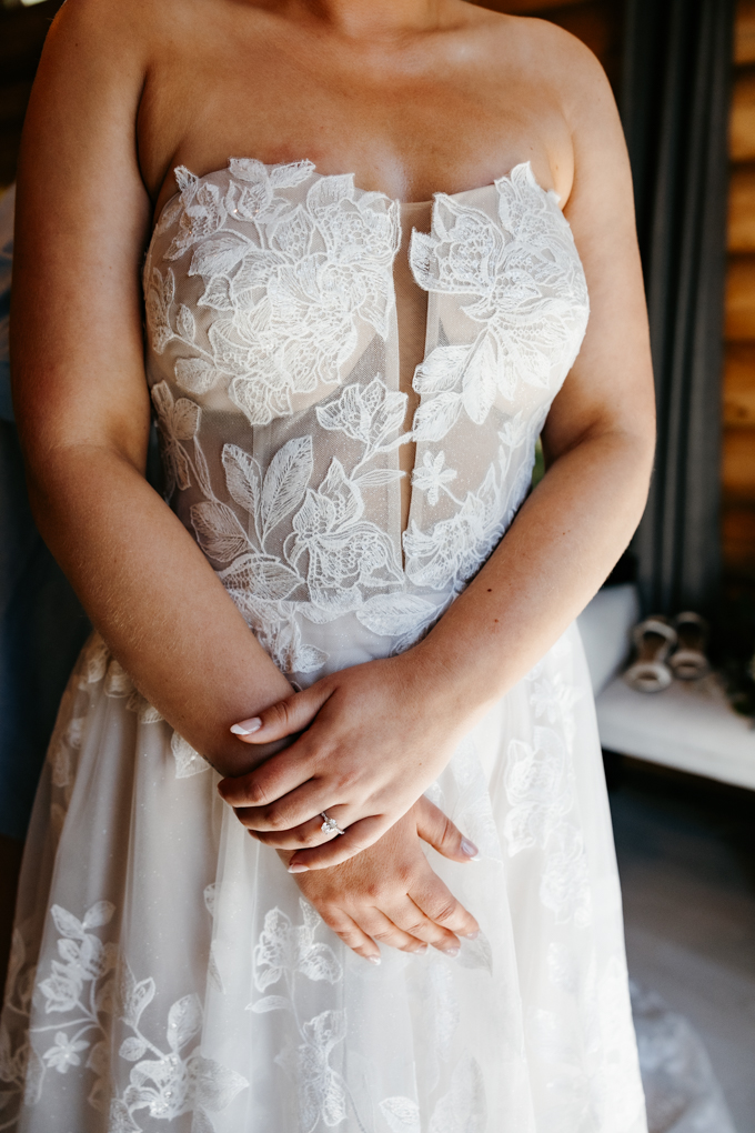 Bride stands in her dress, with her hands crossed in front at ther northern oaks events wedding