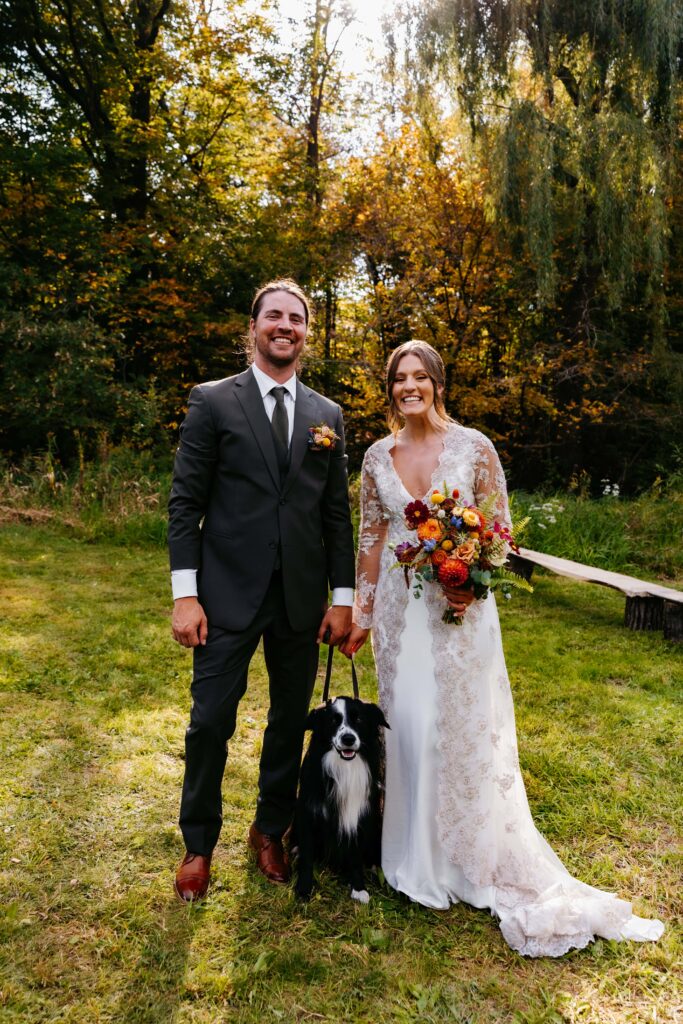 Bride and groom smile with their dog at their st cloud wedding