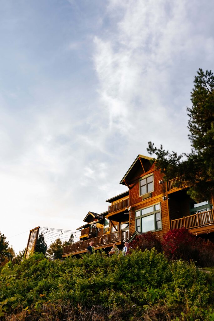 Wooded lodge at Grand Superior Lodge Wedding Venue behind some boulders and greenery