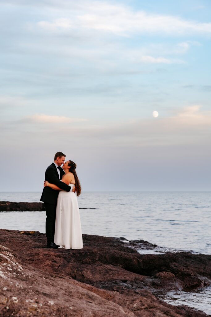 Bride and groom kiss on the beach at superior shores resort wedding venue